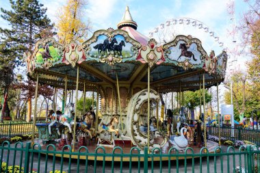 Bucharest, Romania, 13 November 2021: Colourful children colorful carousel with mixed plastic and metallic toys and materials in Parcul Tei (Linden Park) in a sunny autumn day