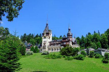Romanya 'nın Sinaia kentinde güneşli bir yaz gününde Bucegi Dağları (Muntii Bucegi) yakınlarındaki Peles Kalesi' nin (Castelul Peles) güzel neo-rönesans binası