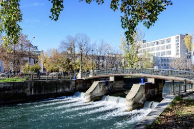 Romanya 'nın Bükreş kentindeki Dambovita nehri üzerindeki eski yeşil metalik paslı köprü, güneşli bir sonbahar gününde