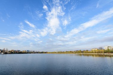 Romanya 'nın Bükreş kentinde, Linden Park' taki (Parcul Tei) ağaçlı manzara, güneşli bir sonbahar gününde beyaz bulutlar ve mavi gökyüzü