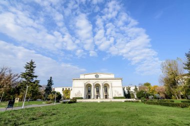 Bucharest, Romania, 6 November 2021 - Romanian National Opera building in a sunny autumn day with white clouds and clear blue sky