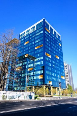 Bucharest, Romania, 21 Nov 2021: Modern glasss building of Floreasca One Tower in Floreasca neighborhood in a sunny autumn day