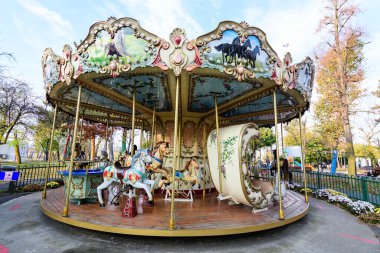 Bucharest, Romania, 13 November 2021: Colourful children colorful carousel with mixed plastic and metallic toys and materials in Parcul Tei (Linden Park) in a sunny autumn day