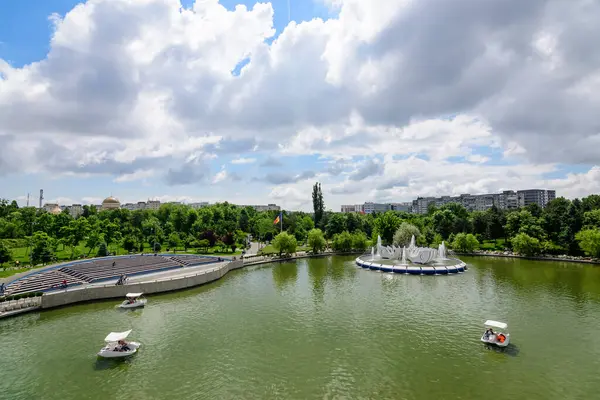 Bükreş, Romanya - 25 Mayıs 2021: Drumul Taberei Parkı 'nda (Parcul Drumul Taberei) modern metalik köprü, göl ve yeşil ağaçlara sahip manzara