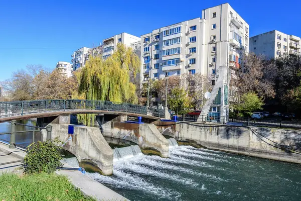 Bucharest, Romania, 20 November 2021: Modern buildings and offices near Dambovita river and cloudy blue sky in the center of the city, in a sunny autumn day