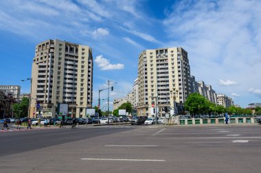 Bükreş, Romanya, 6 Mayıs 2021 - Natiunile Birleşik Meydanı (Piata Natiunile Birliği) yakınlarındaki modern binalar ve Dambovita nehri üzerindeki köprü ve şehrin merkezinde güneşli bir bahar gününde bulutlu mavi gökyüzü