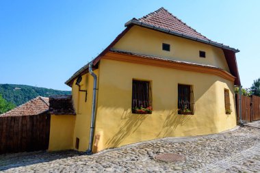 Romanya 'nın Transilvanya (Transilvanya) bölgesindeki Sighisoara kalesinin tarihi merkezinde güneşli bir yaz gününde eski renkli bir ev.