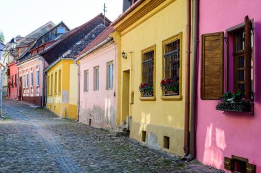 Romanya 'nın Transilvanya (Transilvanya) bölgesindeki Sighisoara kalesinin tarihi merkezinde güneşli bir yaz gününde eski renkli boyalı evler
