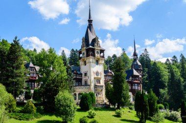 Romanya 'nın Sinaia kentinde güneşli bir yaz gününde Bucegi Dağları (Muntii Bucegi) yakınlarındaki Peles Kalesi' nin (Castelul Peles) güzel neo-rönesans binası