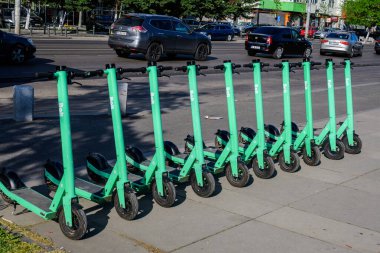 Bükreş, Romanya - 4 Mayıs 2021: Şehir merkezinde vatandaşlar ve turistler için uygun olan özel mobil uygulama kullanılarak kiralık elektrikli scooterlar