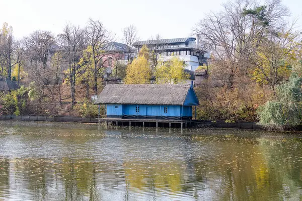 stock image Bucharest, Romania, 6 November 2021: Landscape with blue house on Herastrau lake and large green trees in King Michael I Park (Herastrau) in Bucharest, Romania, in a sunny autumn day