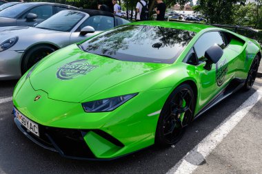 Sibiu, Romanya, 15 Temmuz 2021: Güneşli bir yaz gününde, Özel Arabalar GT etkinliğinde bir sokakta trafikte canlı yeşil bir Lamborghini yarış arabası