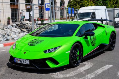 Sibiu, Romanya, 15 Temmuz 2021: Güneşli bir yaz gününde, Özel Arabalar GT etkinliğinde bir sokakta trafikte canlı yeşil bir Lamborghini yarış arabası
