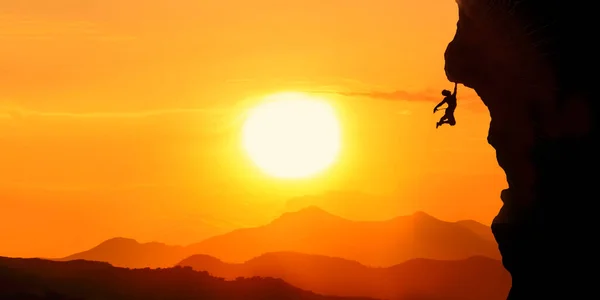 stock image silhouette of a man with a backpack on the top of the mountain