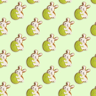 Paskalya yumurtalı tavşan şeklinde kurabiyeler. Açık yeşil arka planda neşeli Paskalya deseni. Üst görünüm.