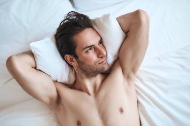 Relaxing man lying on bed