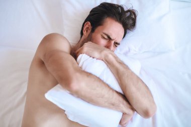 Man sleeping peacefully on white bed