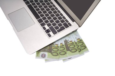 Taşınabilir bilgisayar ve beyaz arka planda 100 euro banknot, üst görünüm.
