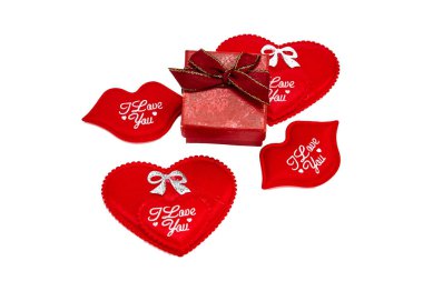 Kırmızı kurdeleli kırmızı kurdele, altın kenarlı yüzük ya da mücevher, dekoratif sembolik kalpler ve yazılı öpücüklerle çevrili seni seviyorum Sevgililer Günü.