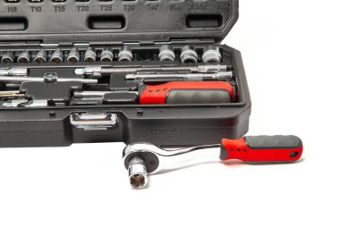 Repair kit in plastic case with wrench separately lying on white background.