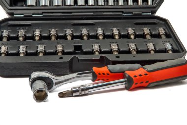 Repair kit in plastic case with wrench separately lying on white background.