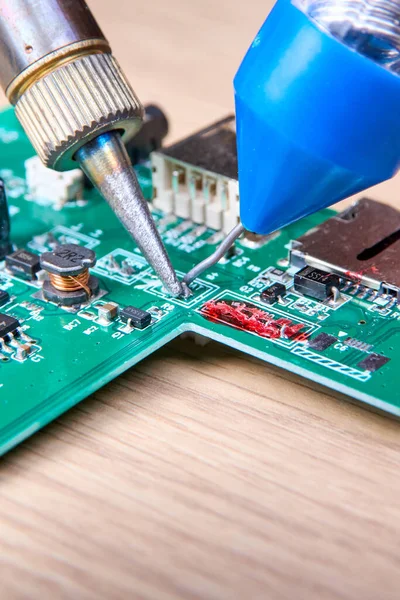 Repair of electronic boards with a soldering iron and tin wire, computer equipment, mobile phone, electronics, repair, upgrade and technology repair concept.