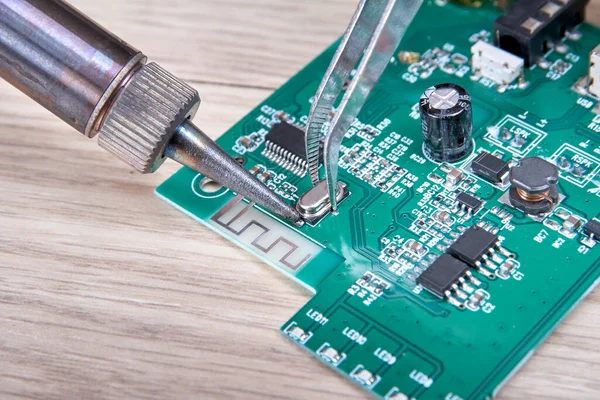 Electronic circuit board repair by replacing the damaged part with a soldering iron, electronic circuit board repair with soldering iron and tin wire, computer equipment, mobile phone, electronics, repair, upgrade and technology repair concept.