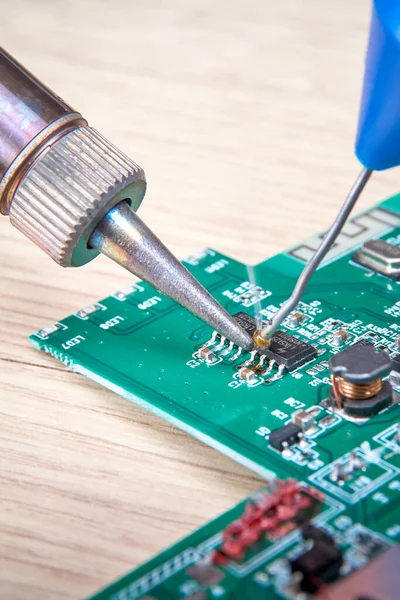 Repair of electronic boards with a soldering iron and tin wire, computer equipment, mobile phone, electronics, repair, upgrade and technology repair concept.