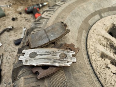 Yıpranmış fren pedleri araçtan çıkarılmış, sürtünme katmanındaki aşınma derecesi ve metal hasar açıkça görülüyor.
