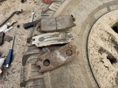 Yıpranmış fren pedleri araçtan çıkarılmış, sürtünme katmanındaki aşınma derecesi ve metal hasar açıkça görülüyor.