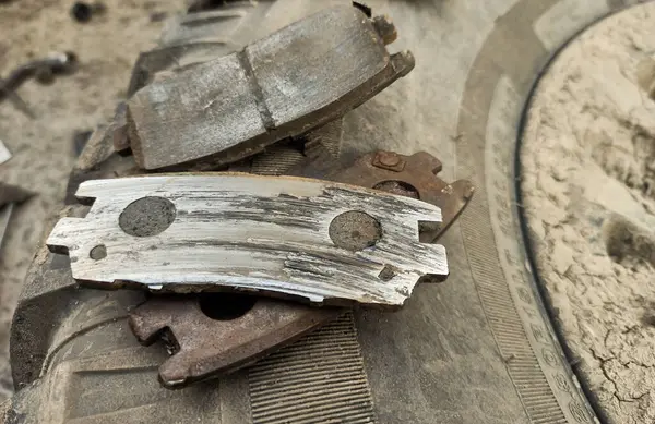 Yıpranmış fren pedleri araçtan çıkarılmış, sürtünme katmanındaki aşınma derecesi ve metal hasar açıkça görülüyor.