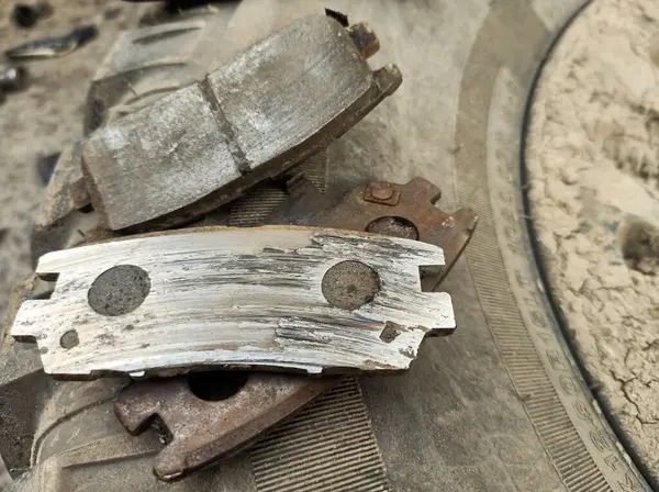 Yıpranmış fren pedleri araçtan çıkarılmış, sürtünme katmanındaki aşınma derecesi ve metal hasar açıkça görülüyor.