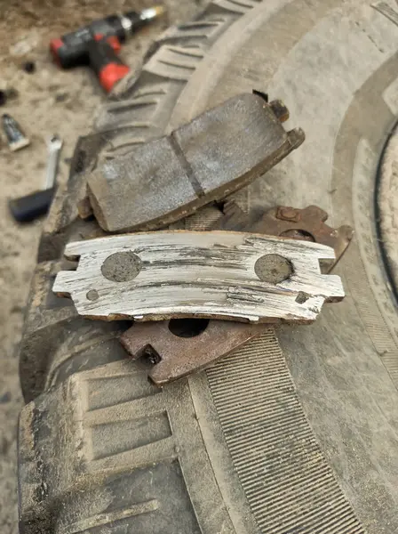 Yıpranmış fren pedleri araçtan çıkarılmış, sürtünme katmanındaki aşınma derecesi ve metal hasar açıkça görülüyor.