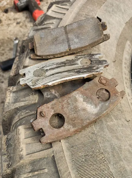 Yıpranmış fren pedleri araçtan çıkarılmış, sürtünme katmanındaki aşınma derecesi ve metal hasar açıkça görülüyor.