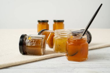 Mini erik kavanozları, kayısı ve tutkulu meyve reçeli. Küçük şişede elma reçeli