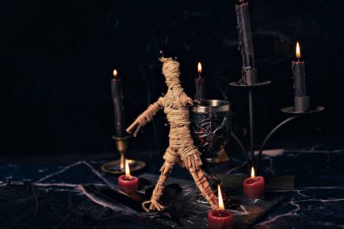 Vudu bebeği ayin sahnesinde yakın çekim, mumlu sihirli masa, büyücülük ve maneviyat konsepti