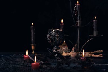 Yakıcı mumlar, kitaplar, mücevherler ve pentagram sembolleri, okült konsept, kara büyü ritüeli içeren cadılık kompozisyonu