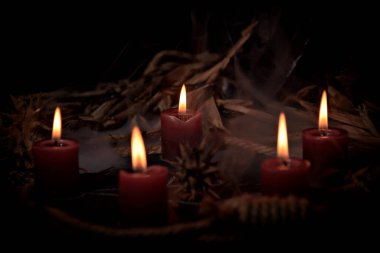 Pentagram amulet and black candle in autumn forest, natural background. Magic esoteric witches ritual. Mysticism, divination, wicca, occultism, witchcraft concept. Samhain sabbat