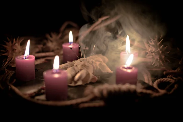 Pentagram amulet and black candle in autumn forest, natural background. Magic esoteric witches ritual. Mysticism, divination, wicca, occultism, witchcraft concept. Samhain sabbat