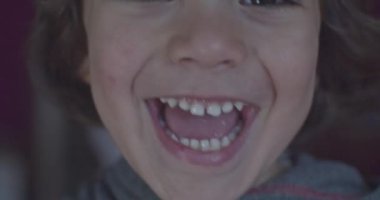 Cinematic close-up of 4-year-old Caucasian boy smiling at 4k camera. Slow Motion