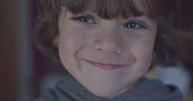 Cinematic close-up of 4-year-old Caucasian boy smiling at 4k camera. Slow Motion