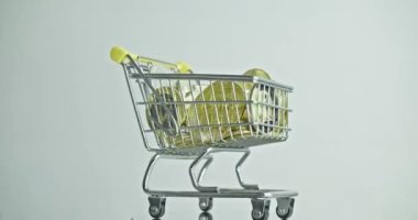 Close-up of a shopping cart with gold Bitcoin cryptocurrency coins