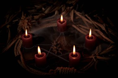 Occultist dripping hot wax on voodoo doll, magic rituals, black spell, horror