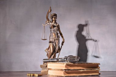 Ön plandaki silah adaletin bir göstergesidir. Silah ve adalet kullanımı kavramı