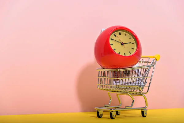一辆带有红色和黄色背景的老式闹钟的超市推车 商场概念 — 图库照片