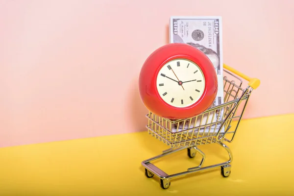 ピンクと黄色の背景に古いヴィンテージ目覚まし時計とスーパーマーケットのトロリー ショッピング スーパーマーケット モールコンセプト — ストック写真