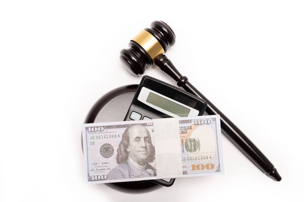 An isolated image of a judges gavel on a stack of cash with a calculator, signifying legal fines or bail