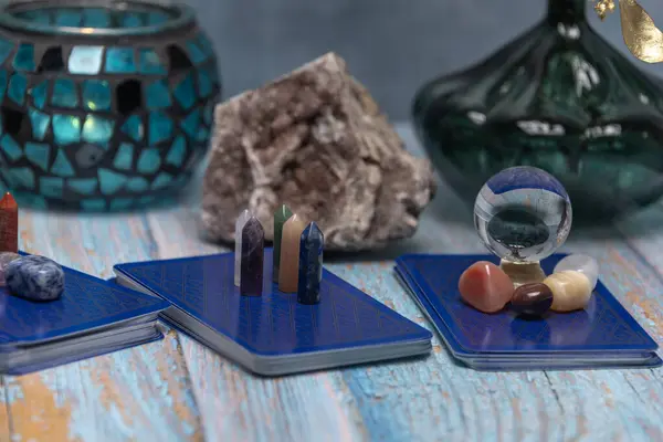 An intimate tarot reading session arrangement featuring vibrant crystals, tarot cards, and a geode on a rustic wooden table