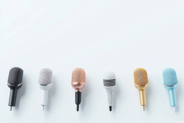 A collection of colorful microphones arranged on a light background, ideal for music, audio, and broadcasting themes. clipart