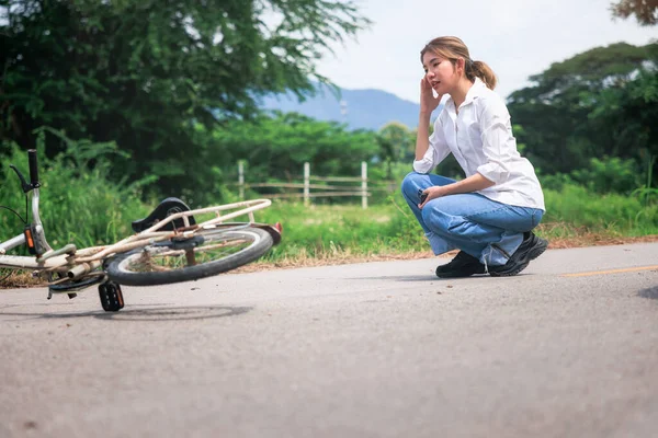 stock image Accident, crash or collision of bicycle at outdoor. Include rider, asian people or young girl to injury on road. Concept for vehicle crash, dangerous, emergency, safety, bike cycling, riding training.